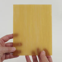 Video of the honey blonde glass plate in beige translucent, 15x19cm, held up and tilted to show its pattern and transparency