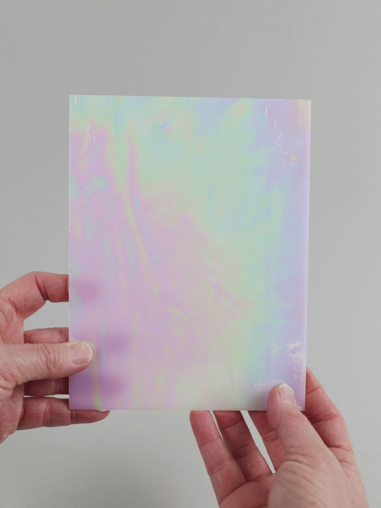 Video of the pearl glass plate in white translucent iridescent, 15x19cm, held up and tilted to show its pattern and transparency
