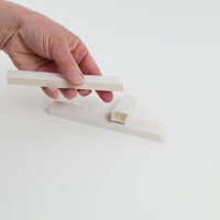 Video of Marble Bars XL Botticino in opaque cream-beige natural marble, 1–20 cm long and 8 mm thick, picked up by hand and turned to show their length, colour and natural veining