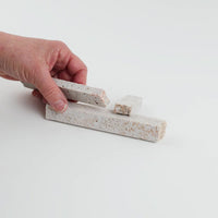 Video of Marble Bars XL Travertine Noce in opaque camel-brown natural travertine, 1–20 cm long and 8 mm thick, picked up by hand and turned to show their length, colour and porous texture
