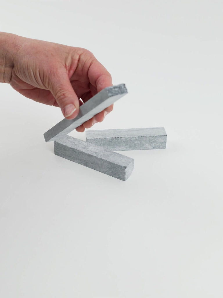 Video of Marble Bars XL Nero Lavica in opaque dark grey natural marble, 1–20 cm long and 8 mm thick, picked up by hand and turned to show their length, colour and natural veining