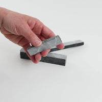 Video of Marble Bars XL Nero Mystic in opaque grey-black natural marble, 1–20 cm long and 8 mm thick, picked up by hand and turned to show their length, colour and natural veining