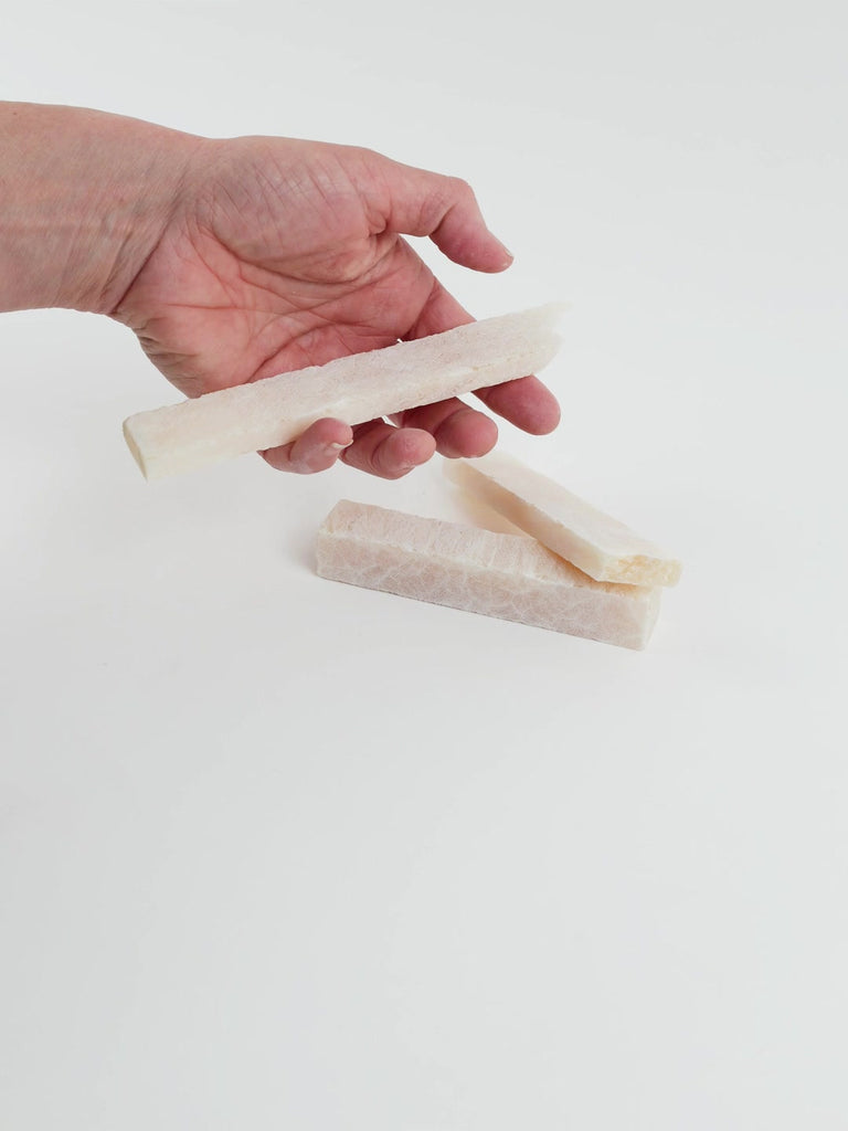 Video of Marble Bars XL Onyx in opaque beige natural onyx, 1–20 cm long and 8 mm thick, picked up by hand and turned to show their length, colour and banded texture