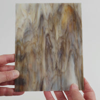 Video of the limestone glass plate in beige, 15x19cm, held up and tilted to show its pattern and transparency