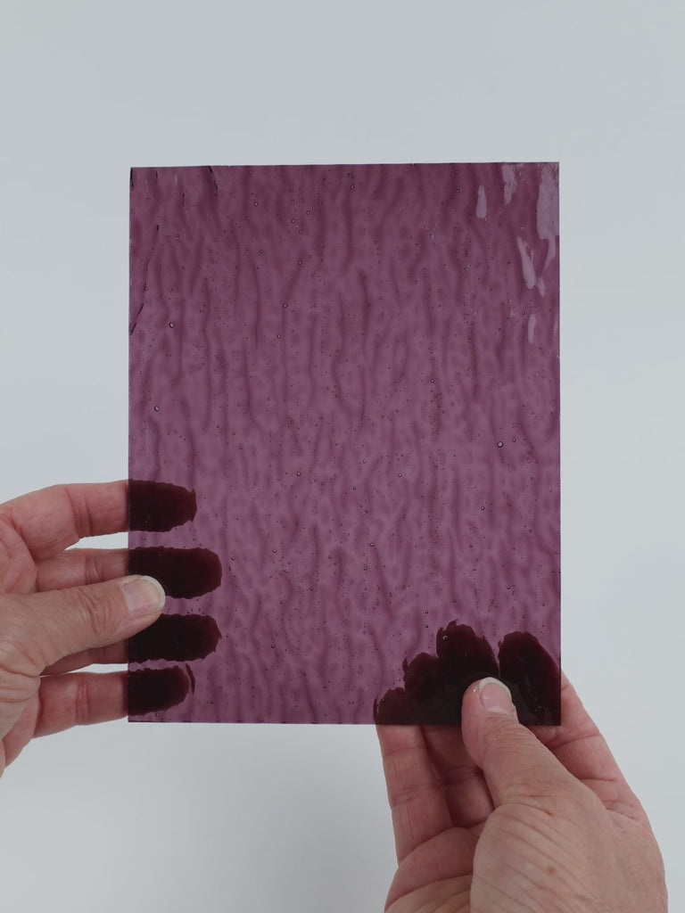 Video of the Violet Ripple glass plate in ripple hammered transparent purple, 15x19cm, held up and tilted to show its pattern and transparency