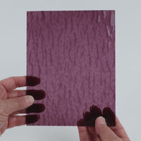 Video of the Violet Ripple glass plate in ripple hammered transparent purple, 15x19cm, held up and tilted to show its pattern and transparency