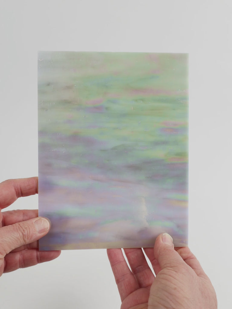 Video of the grey pink iridescent glass plate in grey pink translucent iridescent, 15x19cm, held up and tilted to show its pattern and transparency