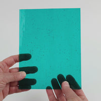 Video of the Teal glass plate in transparent teal, 15x19cm, held up and tilted to show its pattern and transparency