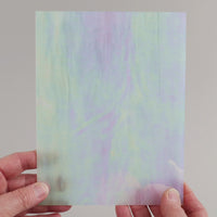 Video of the white iridescent wispy glass plate in semi-transparant white , 15x19cm, held up and tilted to show its pattern and transparency